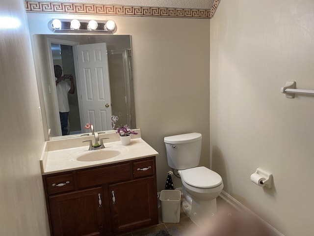 full bathroom featuring a shower with door, vanity, and toilet