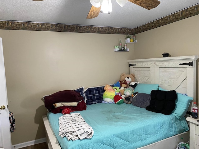 bedroom featuring a textured ceiling, a ceiling fan, and baseboards