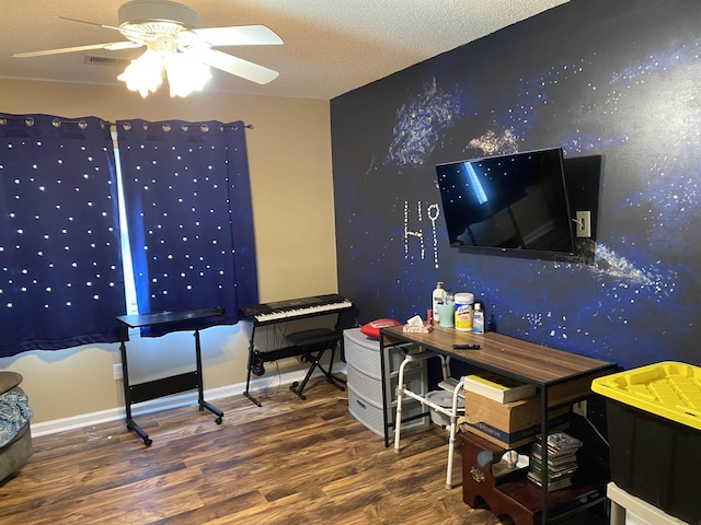 home office featuring ceiling fan, a textured ceiling, baseboards, and wood finished floors