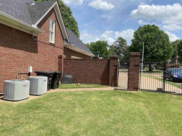 view of yard with cooling unit, a gate, and fence