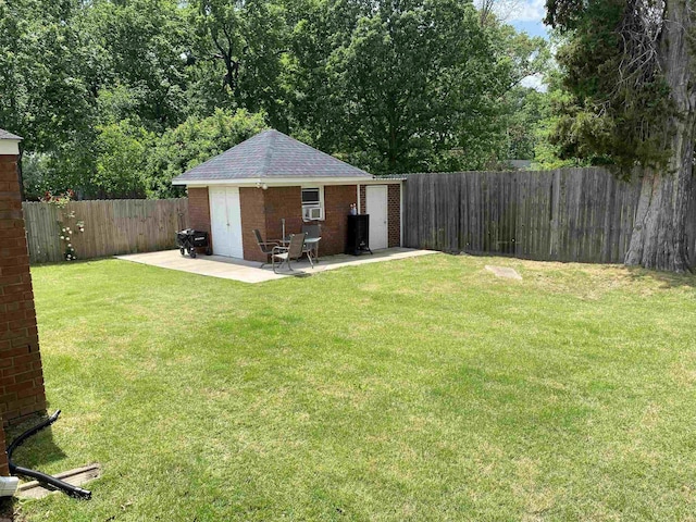 view of yard with a fenced backyard, an outdoor structure, and a patio