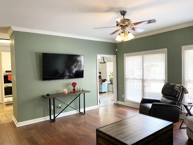 living room featuring baseboards, ornamental molding, and wood finished floors