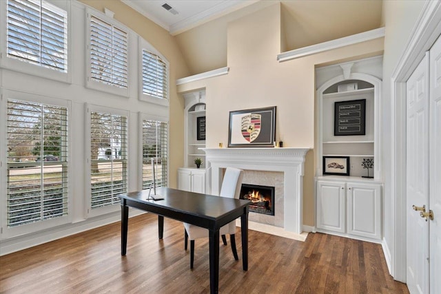 office area featuring a premium fireplace, visible vents, dark wood-type flooring, and ornamental molding