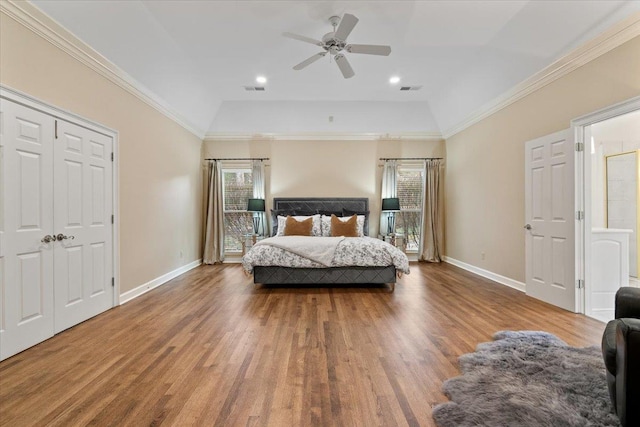 bedroom with baseboards, visible vents, ornamental molding, and wood finished floors