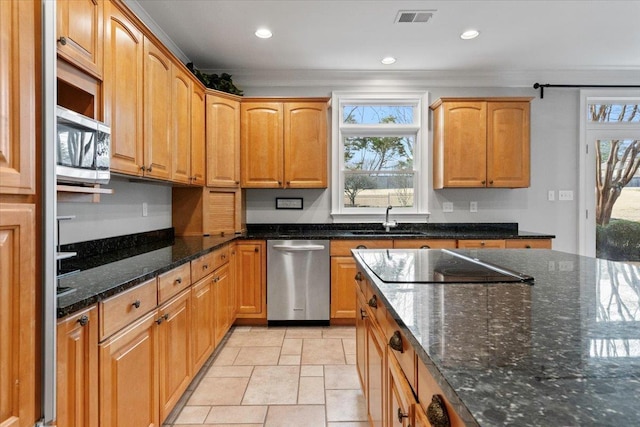 kitchen with a sink, visible vents, appliances with stainless steel finishes, dark stone counters, and crown molding