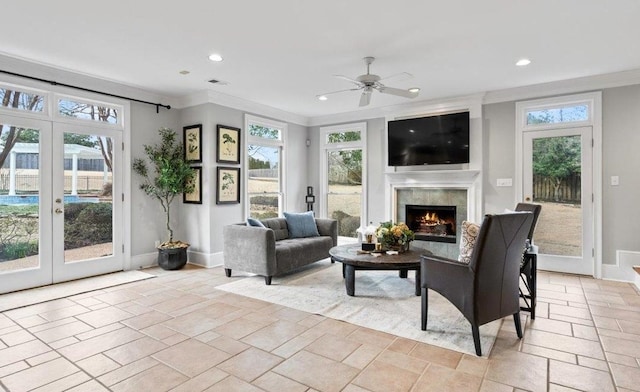 interior space featuring recessed lighting, baseboards, a lit fireplace, french doors, and stone tile flooring