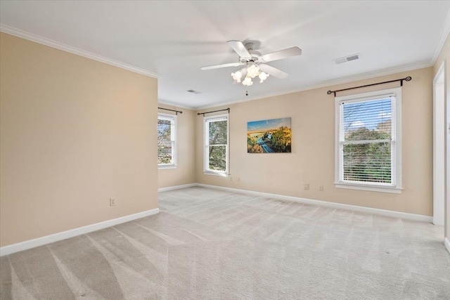 spare room featuring ornamental molding, visible vents, and light carpet