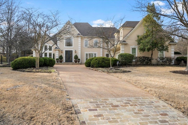 french country style house with driveway and stucco siding