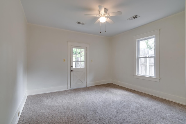 carpeted empty room featuring a ceiling fan, visible vents, and baseboards