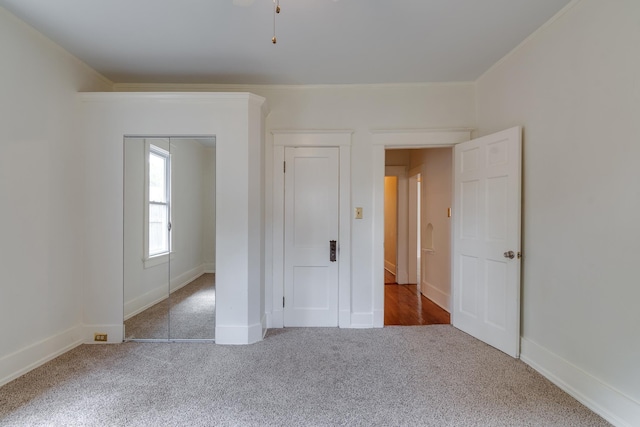 unfurnished bedroom with ornamental molding, carpet flooring, and baseboards