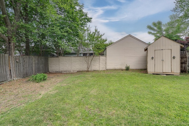 view of yard with a storage shed, a fenced backyard, and an outdoor structure