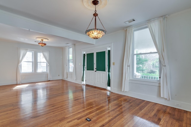 foyer entrance featuring wood-type flooring, visible vents, crown molding, and baseboards