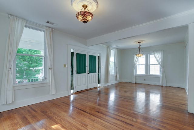 entryway featuring baseboards, wood finished floors, visible vents, and ornate columns