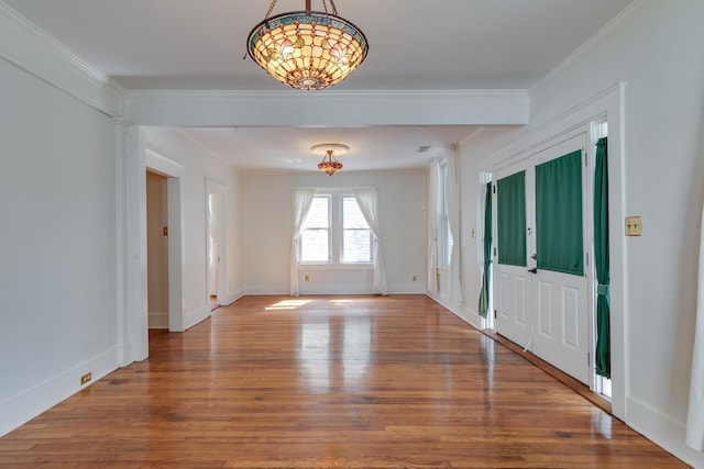 foyer entrance featuring crown molding, baseboards, and wood finished floors