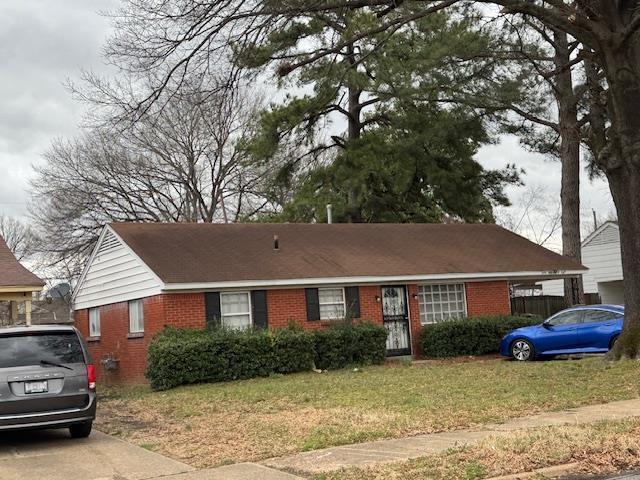 single story home with a front yard and brick siding