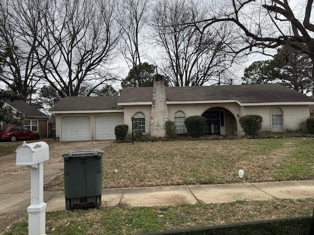 view of front facade featuring a garage, driveway, brick siding, and a chimney