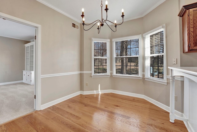 unfurnished dining area featuring baseboards, light wood finished floors, visible vents, and crown molding