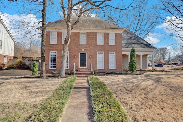 view of front facade with a front yard and brick siding