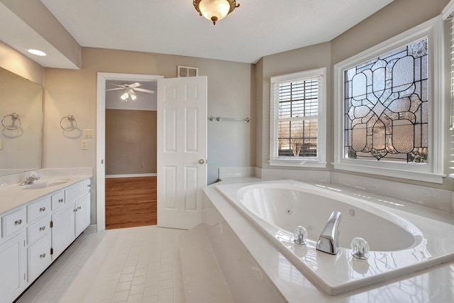 full bathroom featuring a jetted tub, vanity, visible vents, and tile patterned floors