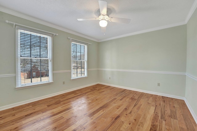 spare room with light wood-style flooring, ornamental molding, ceiling fan, a textured ceiling, and baseboards