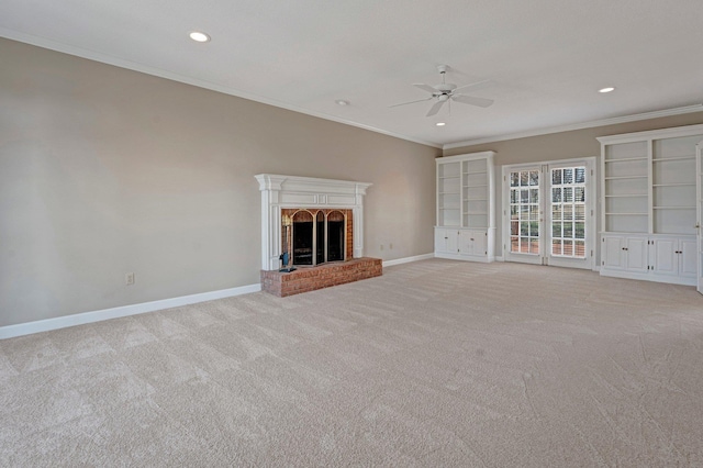 unfurnished living room featuring recessed lighting, light colored carpet, ornamental molding, a brick fireplace, and baseboards