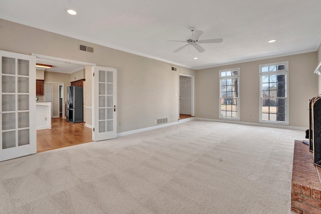 unfurnished living room with french doors, visible vents, and light carpet