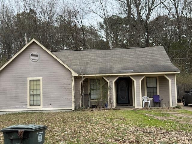 single story home featuring a porch and a front lawn