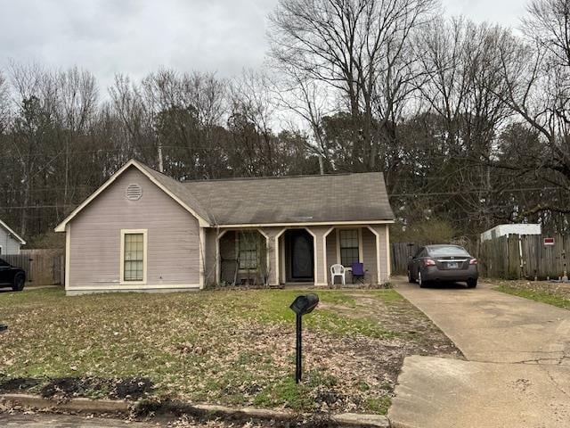 view of front of property featuring concrete driveway, a porch, a front yard, and fence