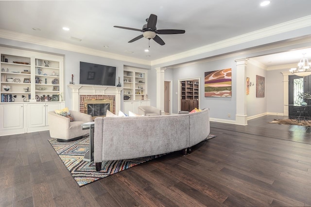 living area with a fireplace, ornate columns, dark wood-type flooring, ornamental molding, and baseboards