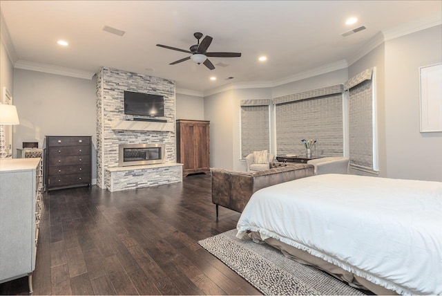 bedroom featuring visible vents, ornamental molding, dark wood-style flooring, and a stone fireplace