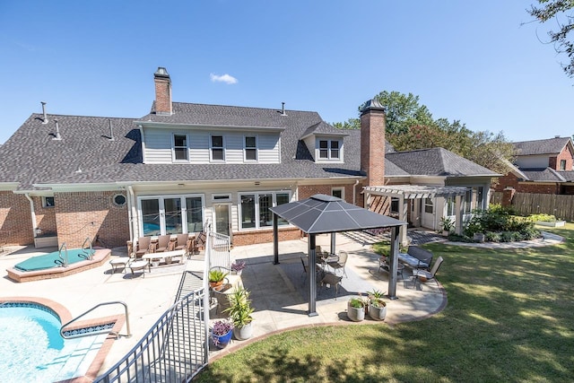 rear view of property featuring a patio, a chimney, fence, a pergola, and brick siding