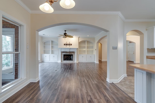 unfurnished living room featuring ceiling fan, baseboards, dark wood-style flooring, and a tile fireplace