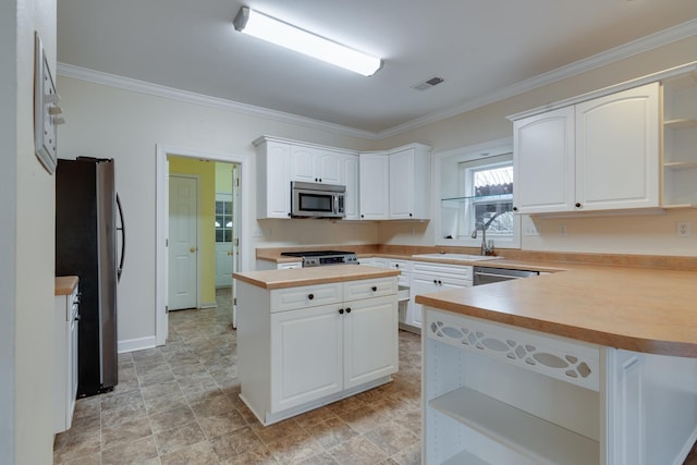 kitchen with visible vents, appliances with stainless steel finishes, ornamental molding, open shelves, and a sink