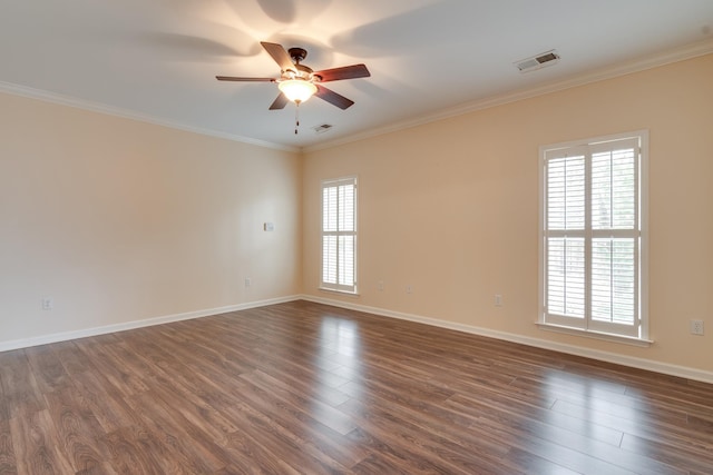 empty room featuring dark wood-style flooring, visible vents, and crown molding