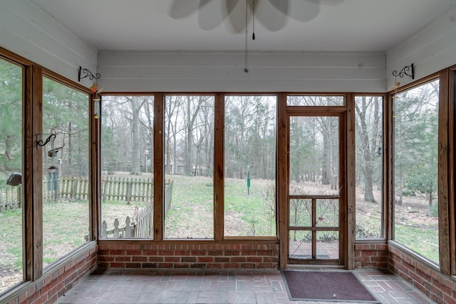 unfurnished sunroom featuring ceiling fan