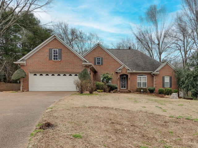 traditional-style house with driveway, roof with shingles, a garage, and brick siding