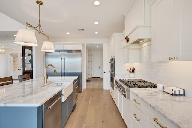 kitchen featuring light wood finished floors, stainless steel appliances, recessed lighting, decorative backsplash, and white cabinets