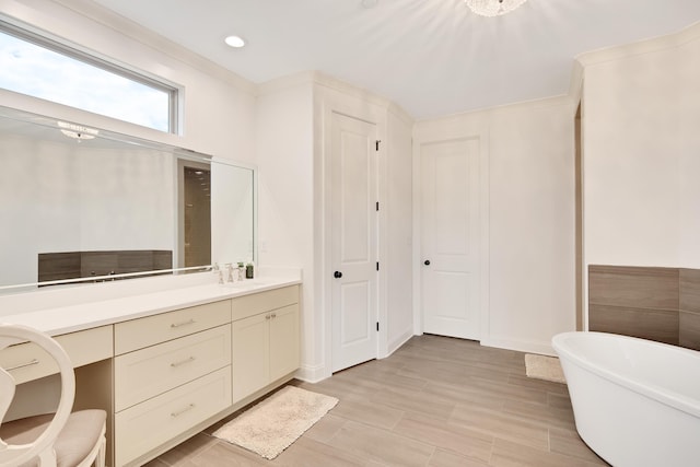 full bath featuring a freestanding tub, recessed lighting, and vanity