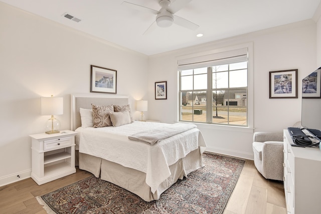 bedroom with ceiling fan, light wood-type flooring, visible vents, and baseboards