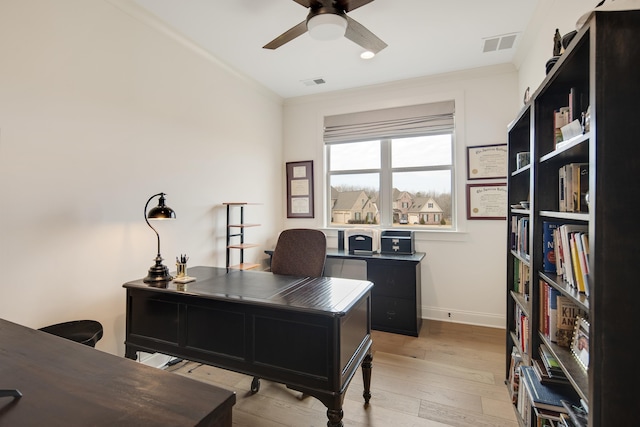 office space featuring visible vents, crown molding, light wood finished floors, and ceiling fan