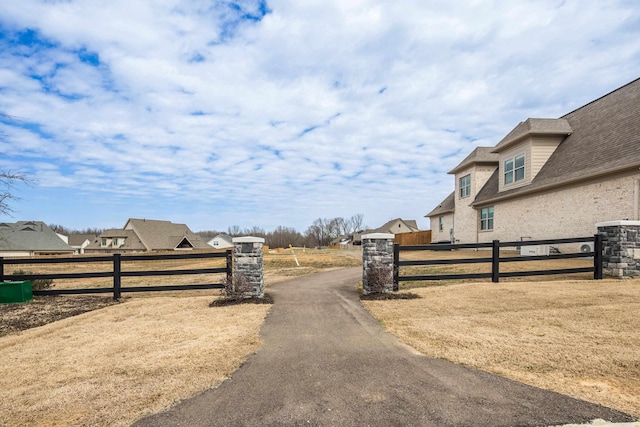 view of road featuring a gated entry and aphalt driveway