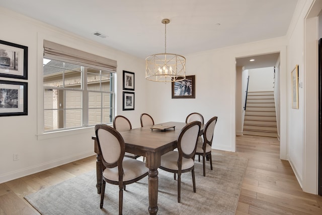 dining room featuring visible vents, stairway, light wood-style flooring, and baseboards