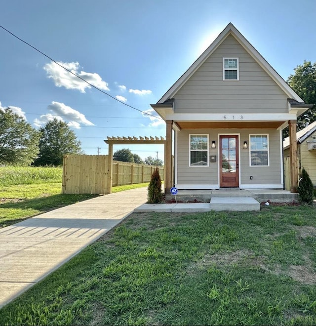 view of front facade with a porch, a front lawn, and fence