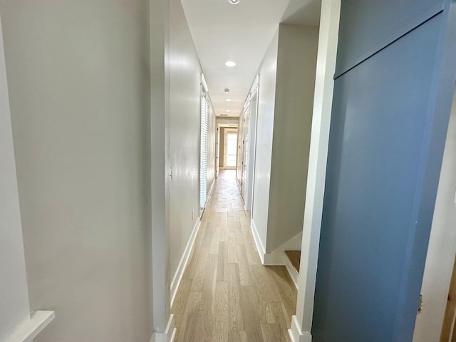 corridor featuring light wood-type flooring, baseboards, and recessed lighting