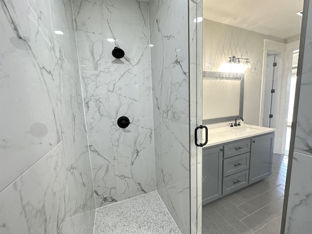 full bathroom with a marble finish shower and vanity