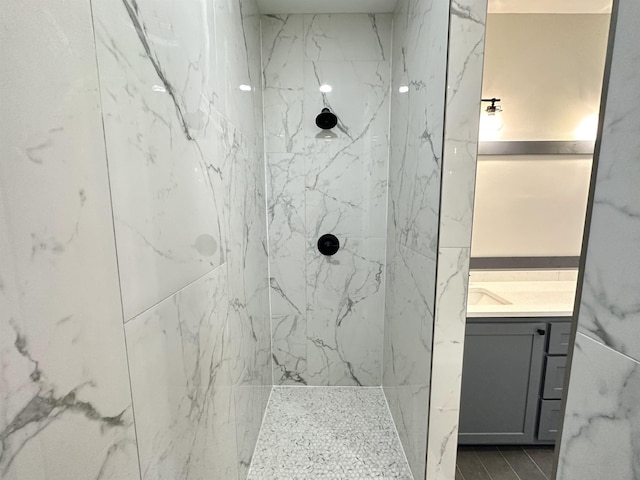 full bath featuring vanity and a marble finish shower