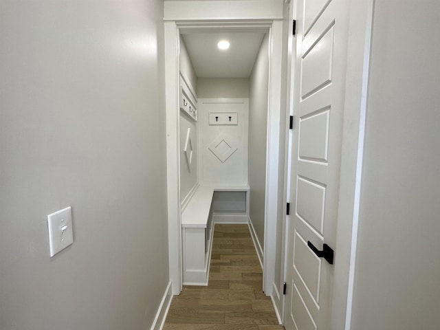 hall featuring wood finished floors and baseboards