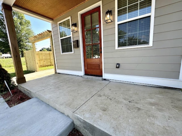 entrance to property with a patio area and fence