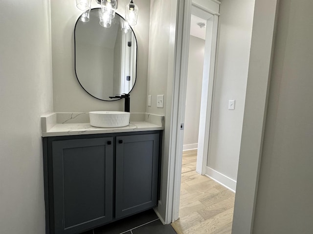 bathroom featuring vanity, baseboards, and wood finished floors