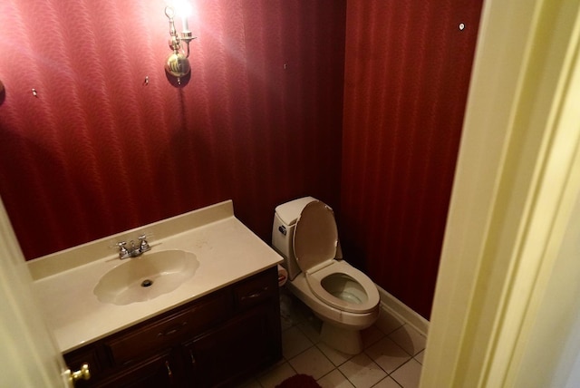 half bath with vanity, toilet, and tile patterned floors